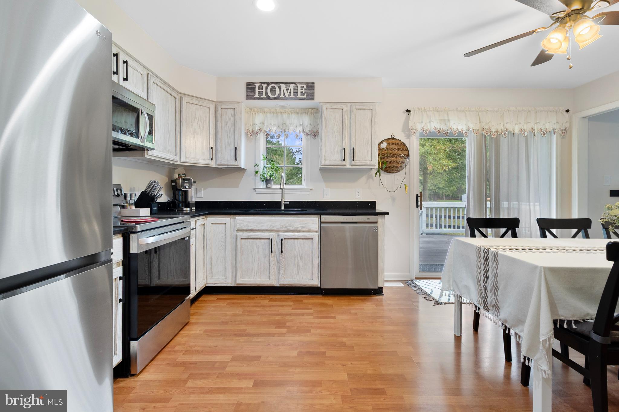 19821 Foggy Bottom Road Bluemont, VA 20135 - Photo 29 of 92 a kitchen with stainless steel appliances granite countertop a white cabinets a sink a stove a dining table and chairs