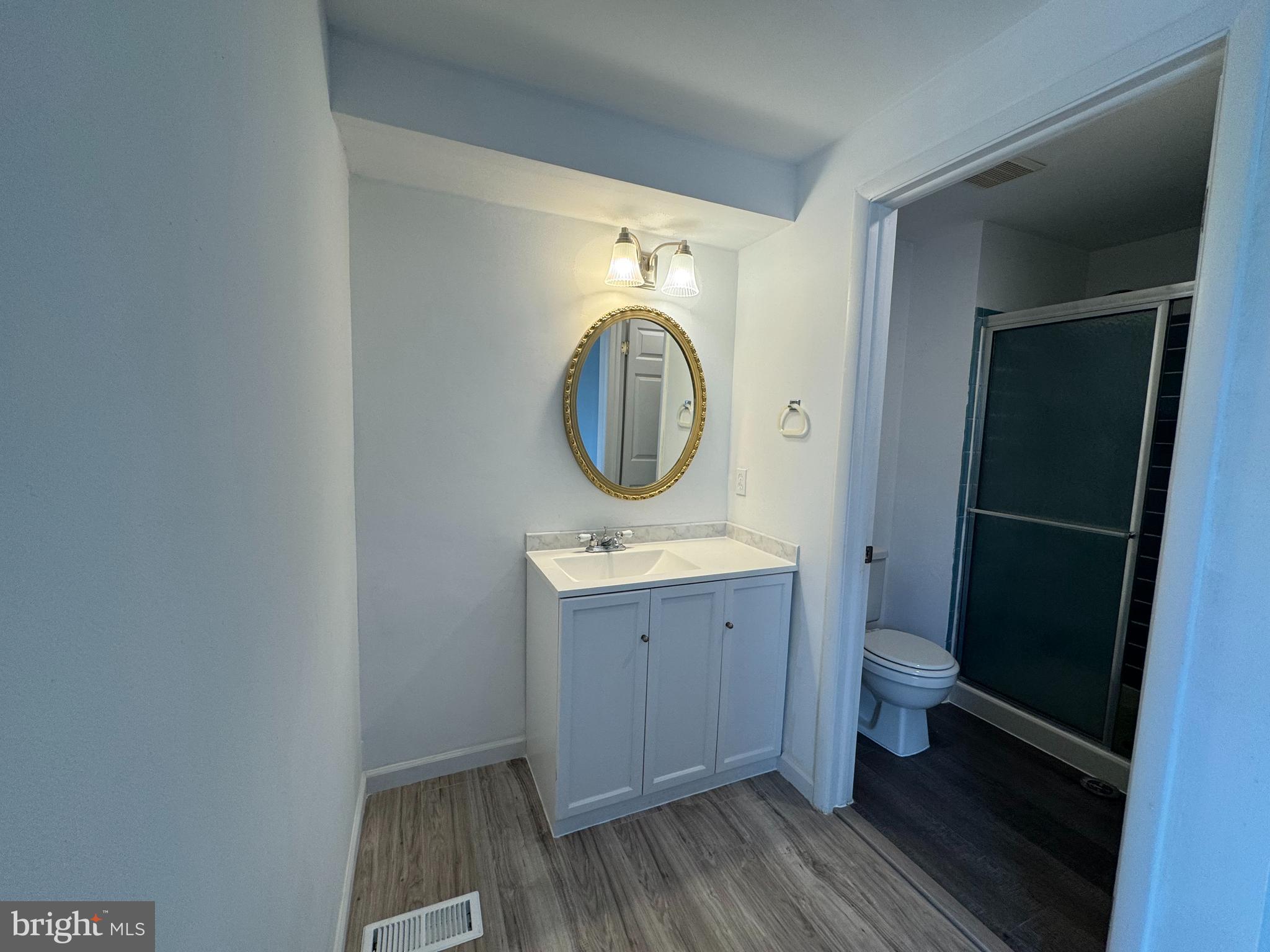 1757 Carriage Way Frederick, MD 21702 - Photo 24 of 42 a bathroom with a granite countertop toilet a sink and a mirror