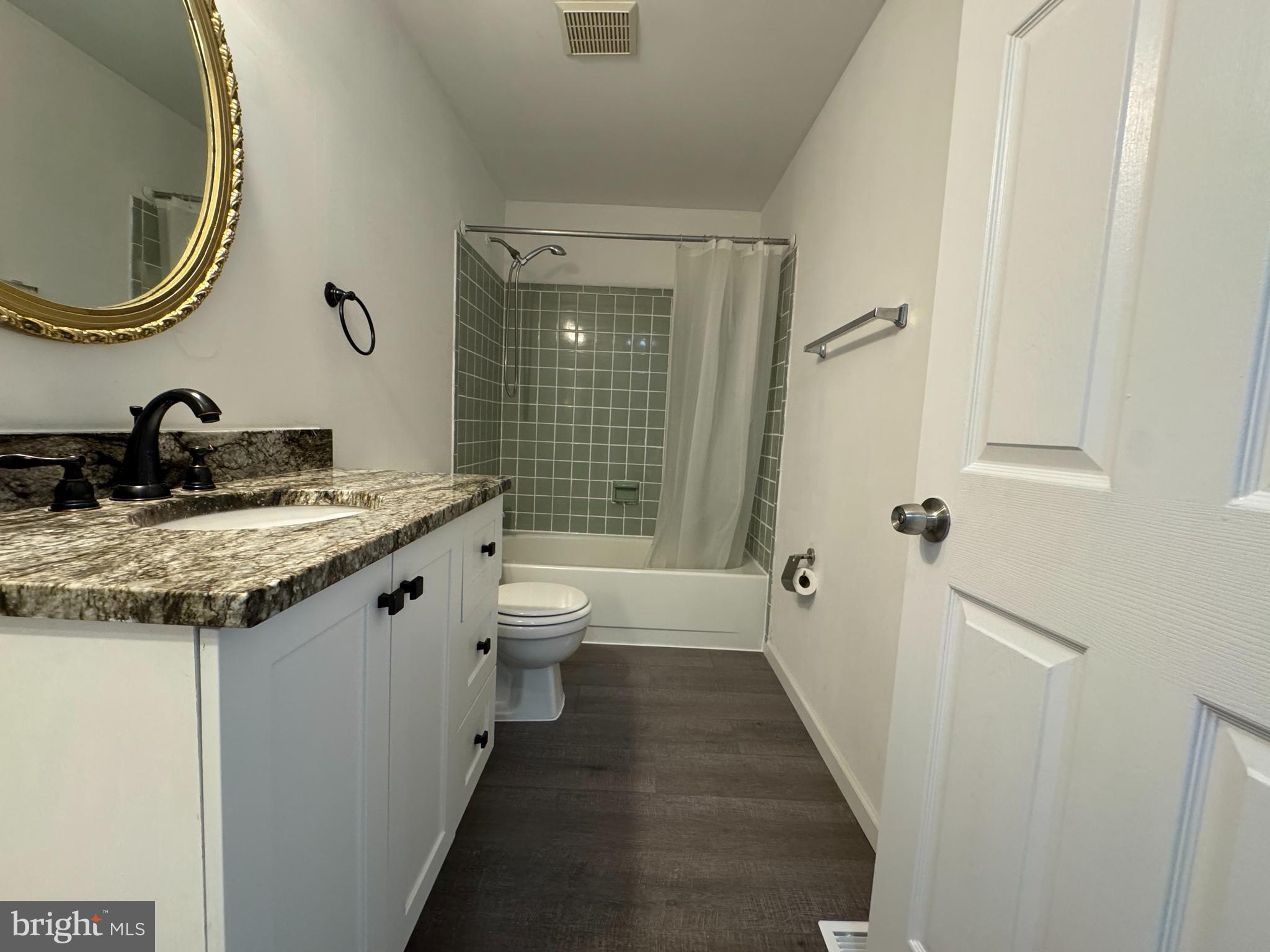 1757 Carriage Way Frederick, MD 21702 - Photo 31 of 42 a bathroom with a granite countertop toilet a sink and a mirror