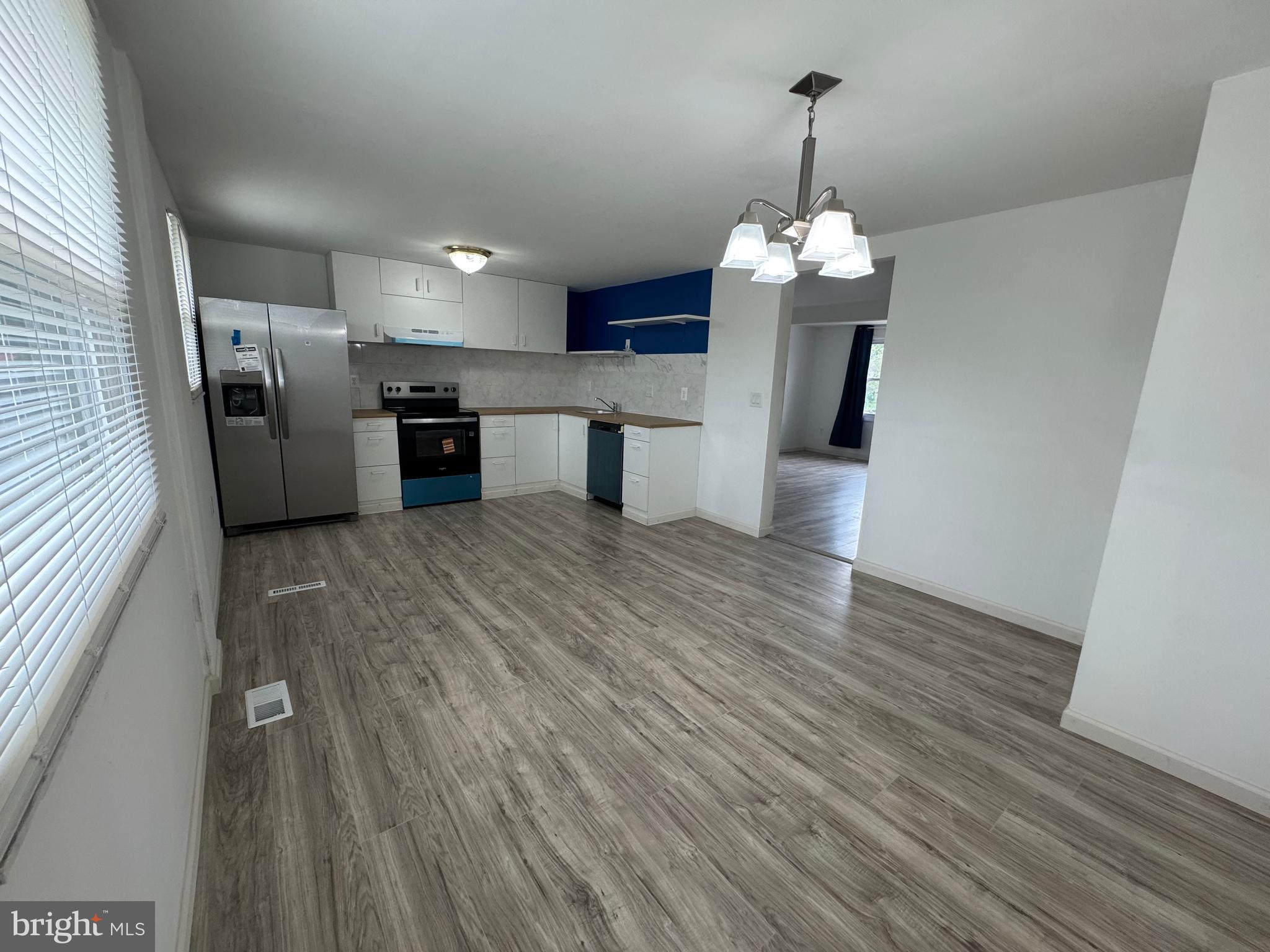 1757 Carriage Way Frederick, MD 21702 - Photo 4 of 42 a view of a kitchen with granite countertop wooden floors stainless steel appliances and a window