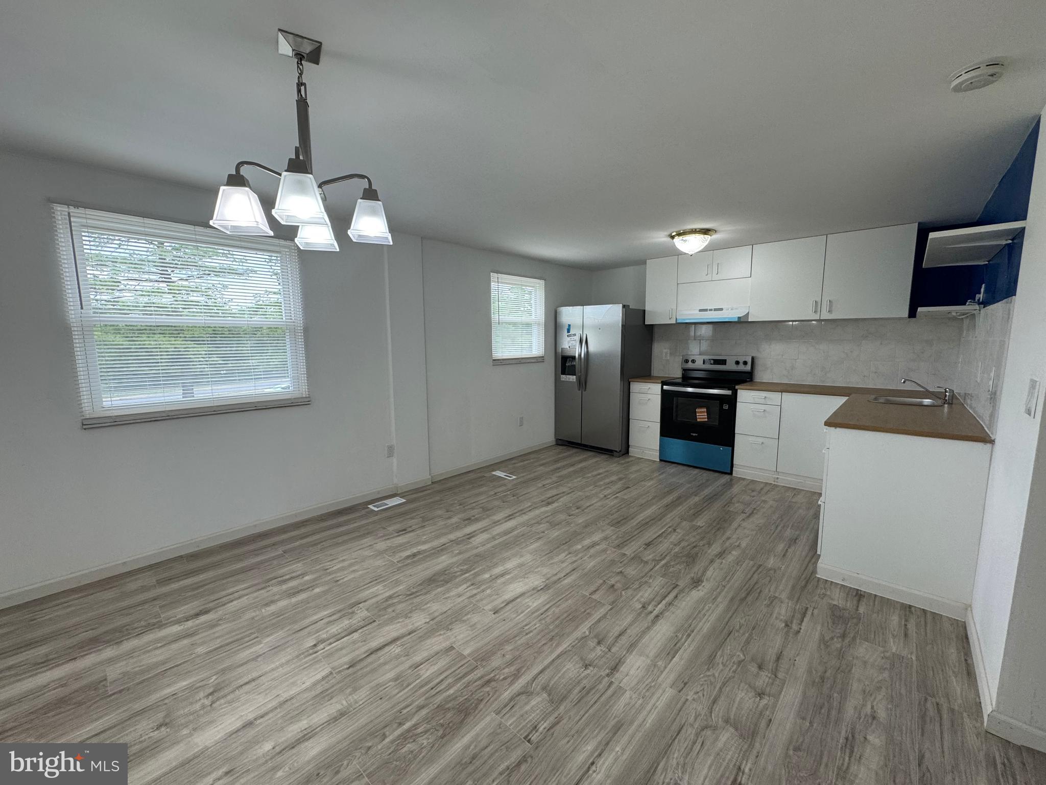 1757 Carriage Way Frederick, MD 21702 - Photo 7 of 42 a view of a kitchen with a stove wooden cabinet wooden floor and chandelier