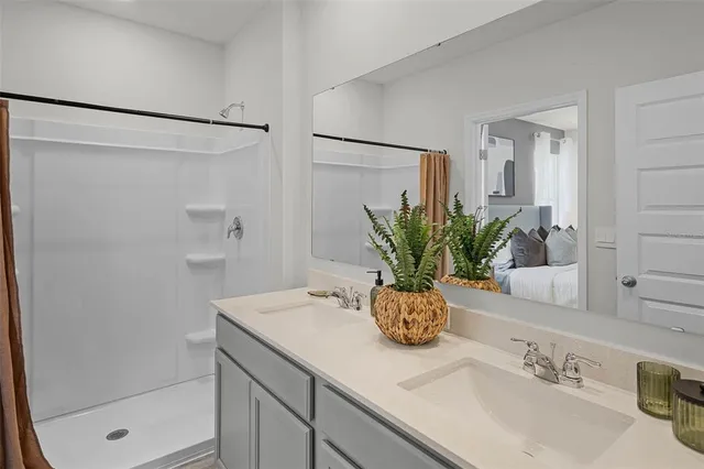 a bathroom with a granite countertop sink a mirror and a shower