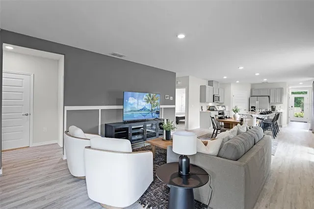 a living room with furniture and a wooden floor