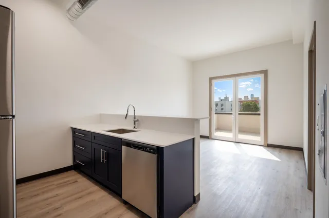 a kitchen with stainless steel appliances granite countertop a sink and wooden floor