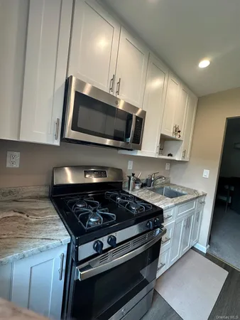 a kitchen with stainless steel appliances a stove a sink and microwave