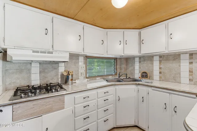 a kitchen with granite countertop white cabinets and a sink