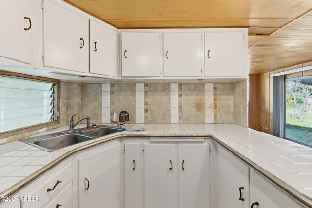 a kitchen with granite countertop a sink and cabinets