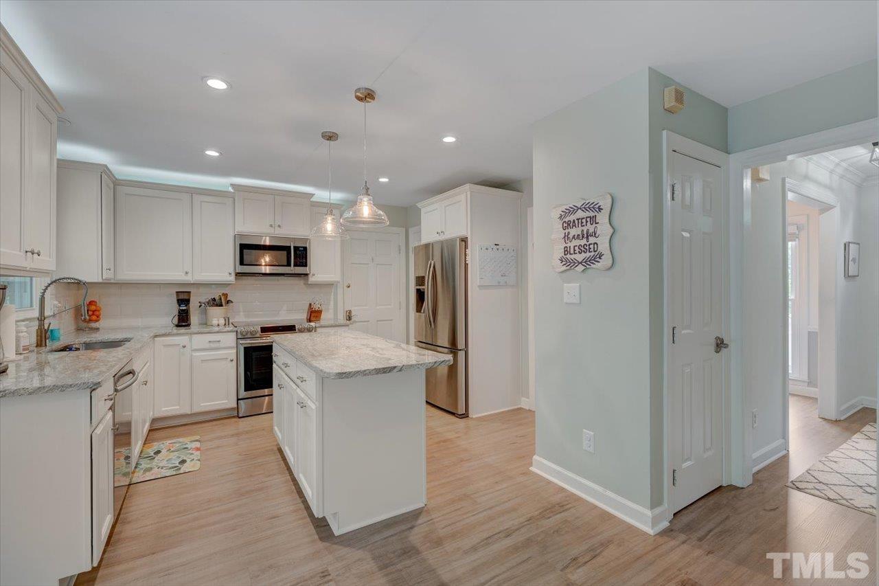 22 Swallows Ridge Court Durham, NC 27713 - Photo 12 of 33 a kitchen with white cabinets and stainless steel appliances