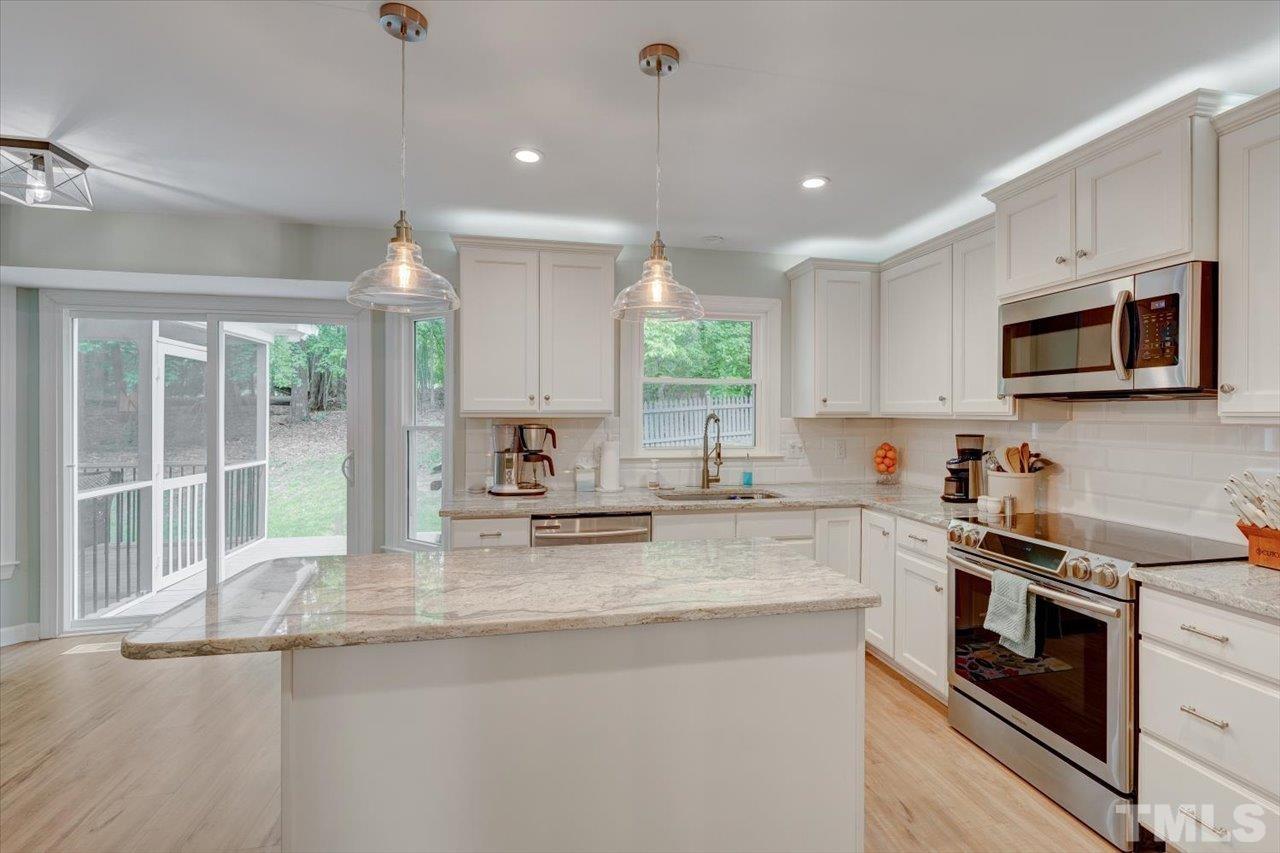 22 Swallows Ridge Court Durham, NC 27713 - Photo 14 of 33 a kitchen with kitchen island granite countertop a sink cabinets stainless steel appliances and a counter top space