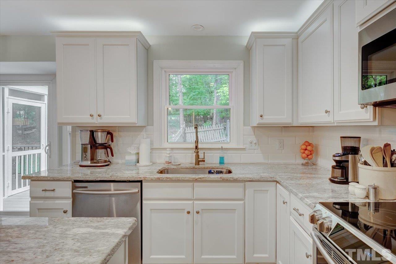 22 Swallows Ridge Court Durham, NC 27713 - Photo 16 of 33 a kitchen with granite countertop white cabinets and white appliances
