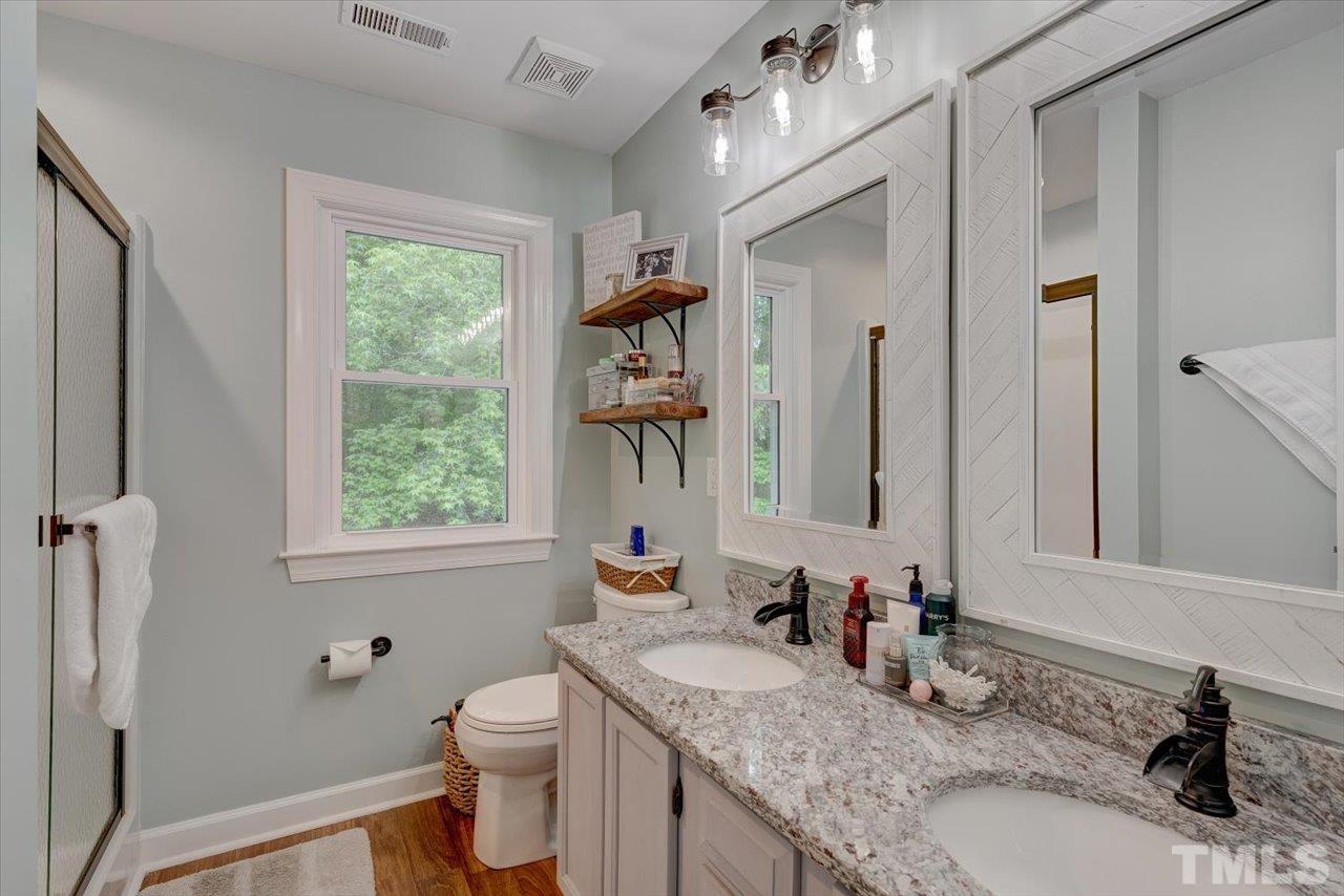 22 Swallows Ridge Court Durham, NC 27713 - Photo 24 of 33 a bathroom with a granite countertop sink a toilet and a mirror