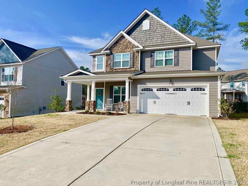 a front view of a house with yard and parking