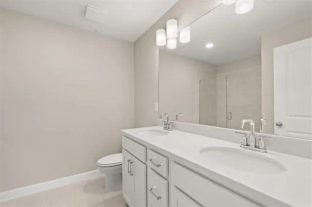 a bathroom with a granite countertop sink a toilet and a mirror