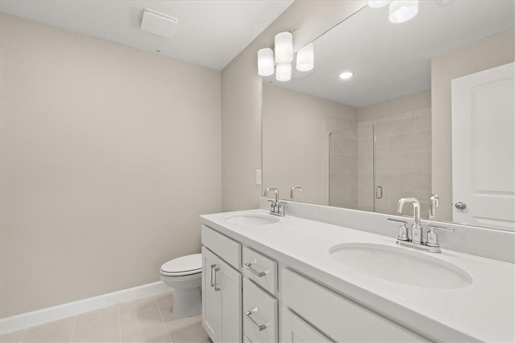 4561 Moray Drive Mableton, GA 30126 - Photo 17 of 34 a bathroom with a granite countertop sink a toilet and a mirror