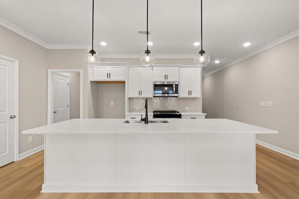 4561 Moray Drive Mableton, GA 30126 - Photo 7 of 34 a kitchen with stainless steel appliances a stove a sink and white cabinets