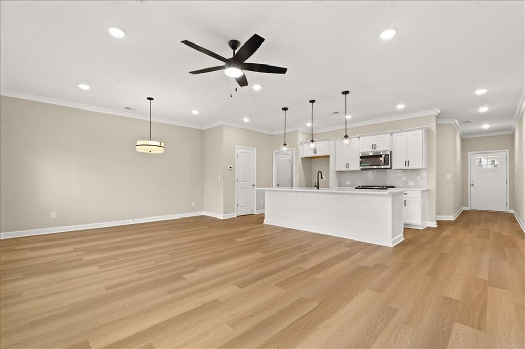 4561 Moray Drive Mableton, GA 30126 - Photo 8 of 34 a large white kitchen with kitchen island a stove a sink dishwasher and a refrigerator with wooden floor