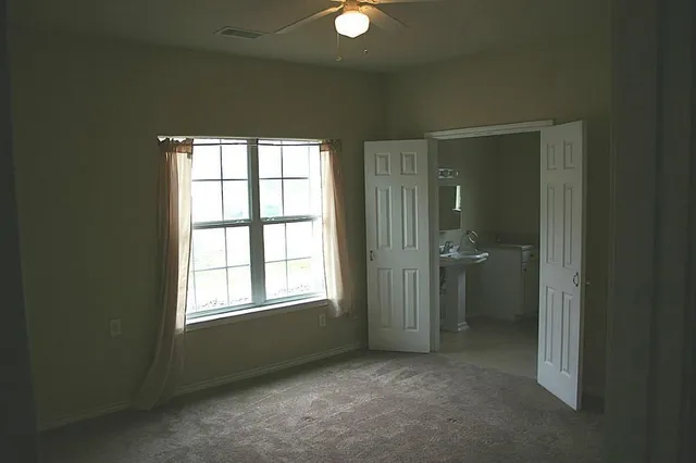 an empty room with windows and closet