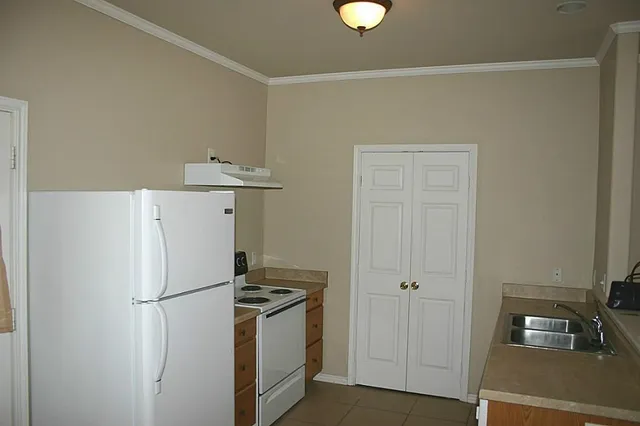 a white refrigerator freezer and a stove sitting inside of a kitchen