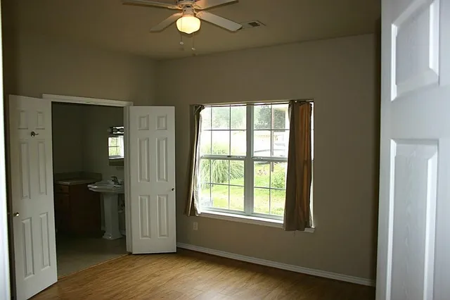 an empty room with wooden floor and a window