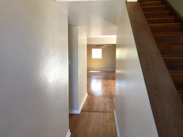 a view of empty room with wooden floor and fireplace