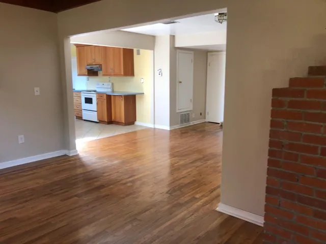 a view of a livingroom with wooden floor a fireplace and window
