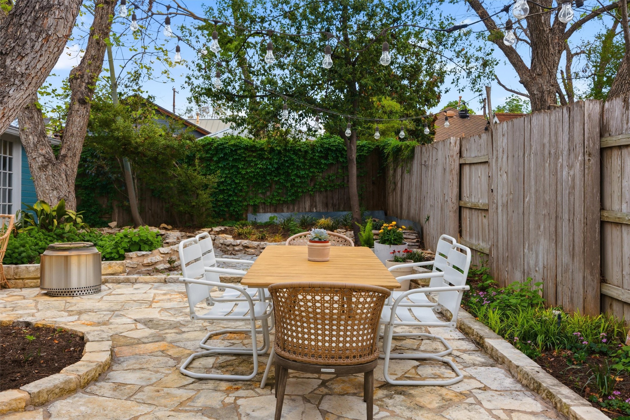 1507 Wethersfield Road Austin, TX 78703 - Photo 37 of 40 a view of a patio with table and chairs potted plants and large tree
