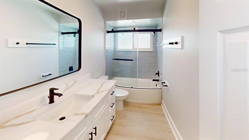 500 129th Avenue East, Unit 1 Madeira Beach, FL 33708 - Photo 12 of 19 a bathroom with a sink a toilet and shower