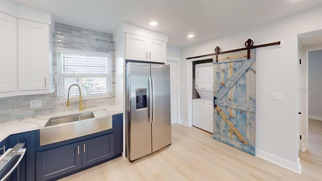 500 129th Avenue East, Unit 1 Madeira Beach, FL 33708 - Photo 9 of 19 a kitchen with granite countertop a refrigerator and a sink