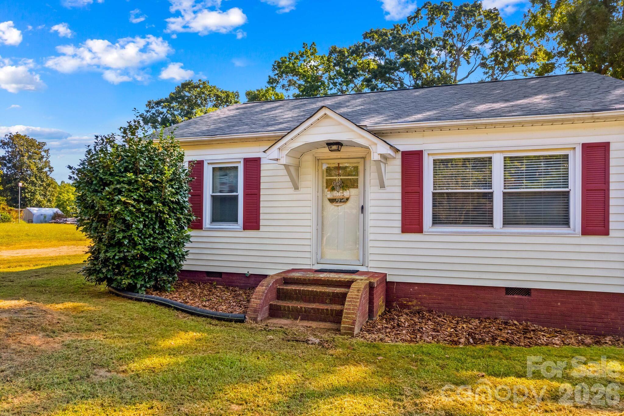 a front view of a house with a yard and potted plants