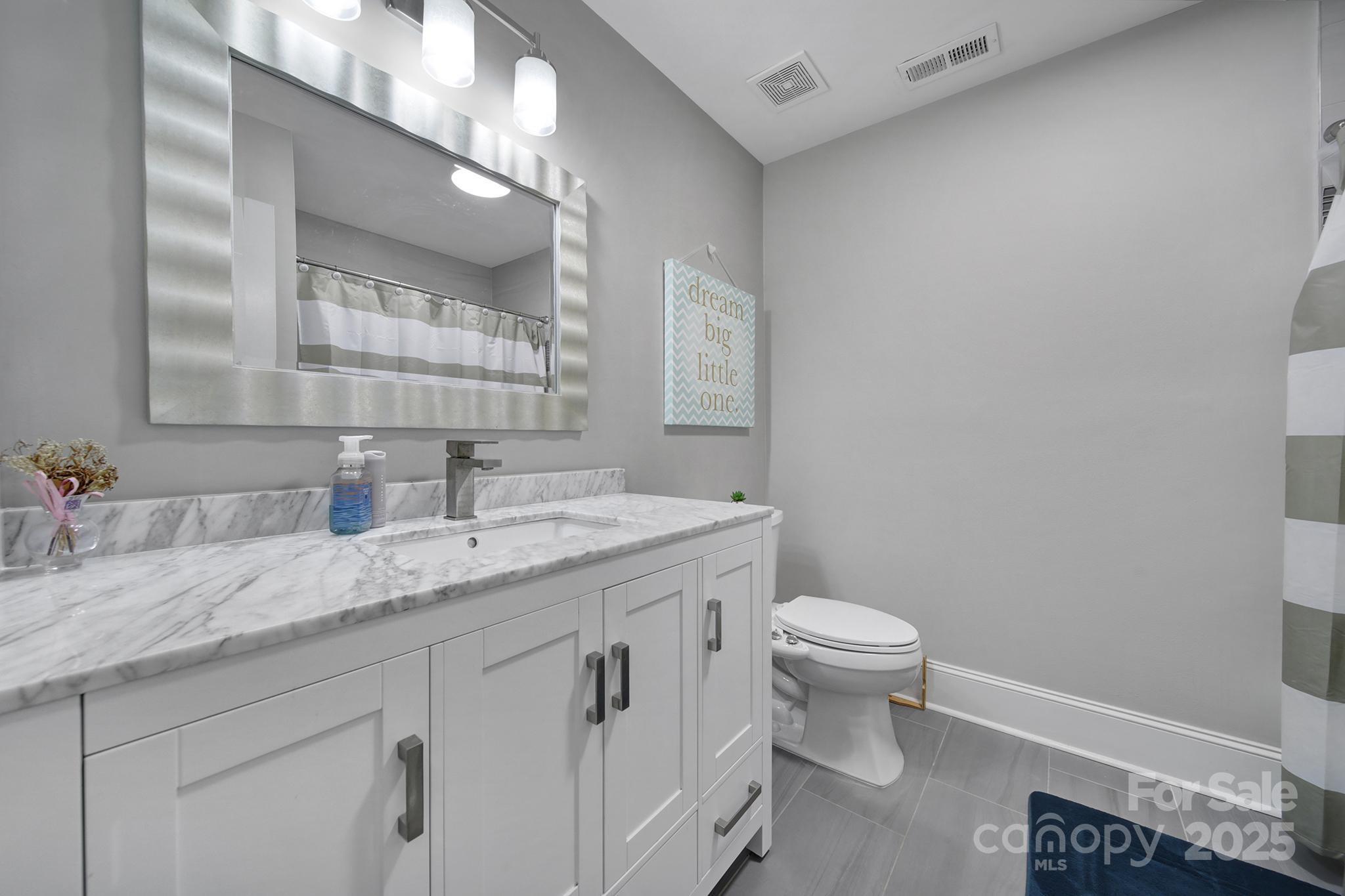 726 Amberly Crossing Fort Mill, SC 29708 - Photo 28 of 47 a bathroom with a granite countertop sink a toilet and a mirror