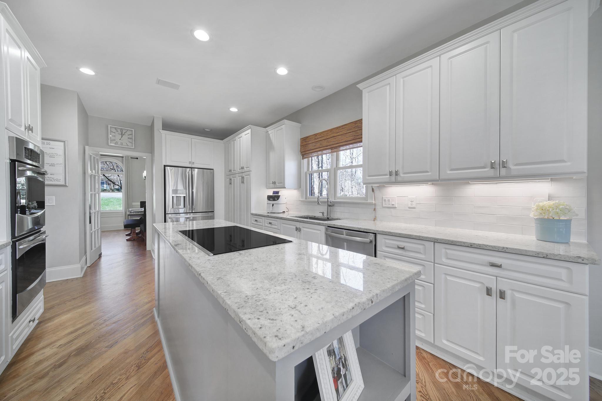 726 Amberly Crossing Fort Mill, SC 29708 - Photo 10 of 47 a kitchen with stainless steel appliances granite countertop a sink dishwasher and a refrigerator with wooden floor