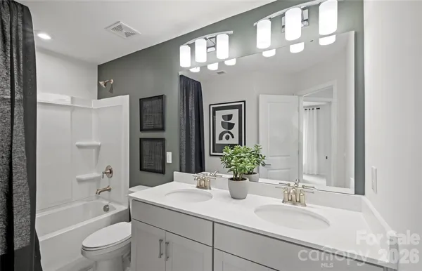 a bathroom with a granite countertop sink a toilet and shower