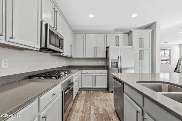 a kitchen with stainless steel appliances granite countertop a sink stove and refrigerator