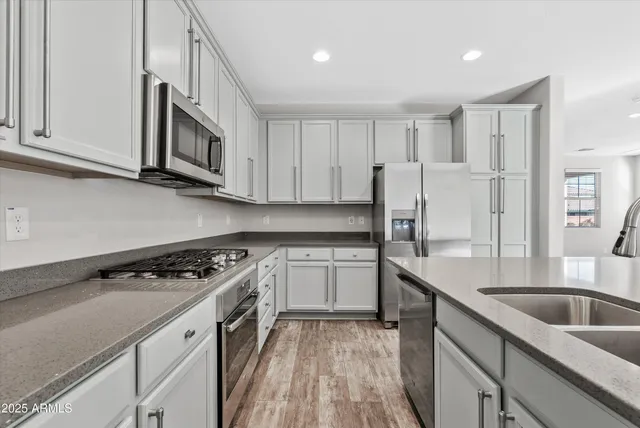a kitchen with stainless steel appliances granite countertop a sink stove and refrigerator