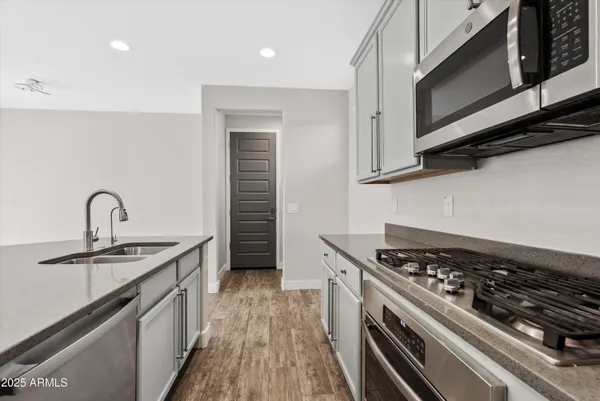 a kitchen with stainless steel appliances a sink dishwasher stove and oven with cabinets