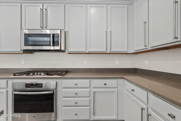 a kitchen with white cabinets and stainless steel appliances