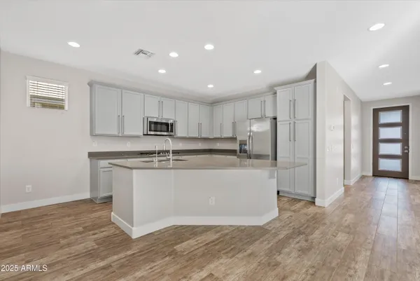 a large kitchen with stainless steel appliances granite countertop a refrigerator and a stove top oven