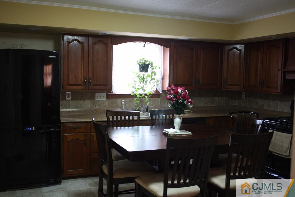 11 Bucknell Road Old Bridge, NJ 08859 - Photo 9 of 16 a kitchen with a table chairs and a refrigerator