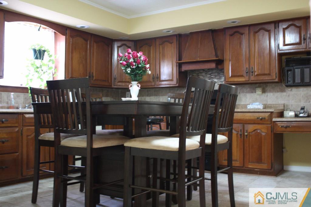 11 Bucknell Road Old Bridge, NJ 08859 - Photo 10 of 16 a kitchen with stainless steel appliances granite countertop a kitchen island a stove a dining table and chairs