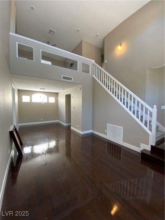 2225 Warm Walnut Drive Las Vegas, NV 89134 - Photo 14 of 38 Unfurnished living room featuring wood-type flooring, a high ceiling, and stairway