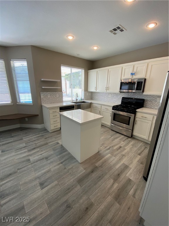 2225 Warm Walnut Drive Las Vegas, NV 89134 - Photo 7 of 38 Kitchen with range, fridge, white cabinetry, decorative backsplash, and recessed lighting