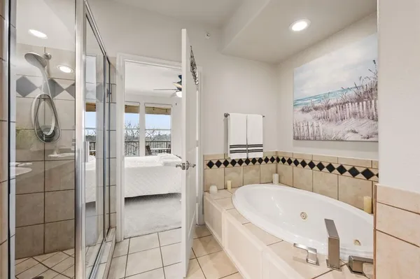 a bathroom with a tub a double vanity sink and shower