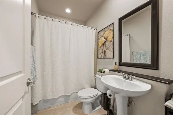 a bathroom with a sink toilet and a mirror