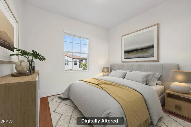 a bedroom with a bed and a painting on the wall