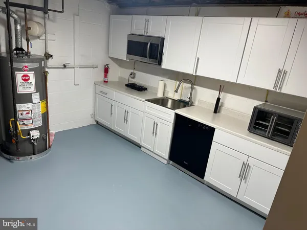 a kitchen with stainless steel appliances a sink a stove a microwave a refrigerator and cabinets