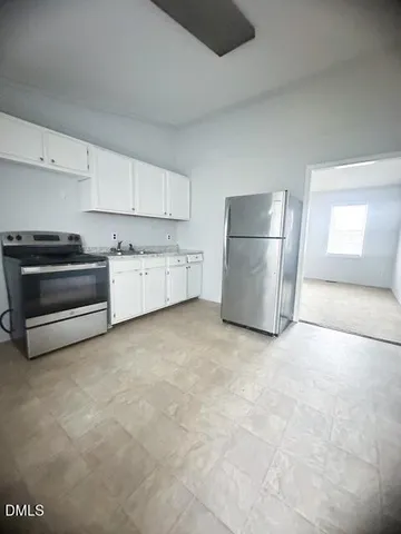 a room with a stove top oven and refrigerator