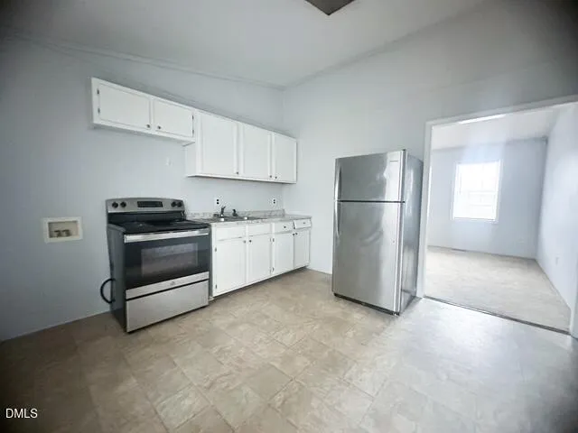 a kitchen with a refrigerator sink and cabinets