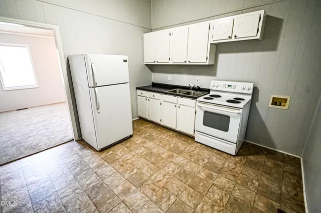 a kitchen with a white stove top oven and a refrigerator