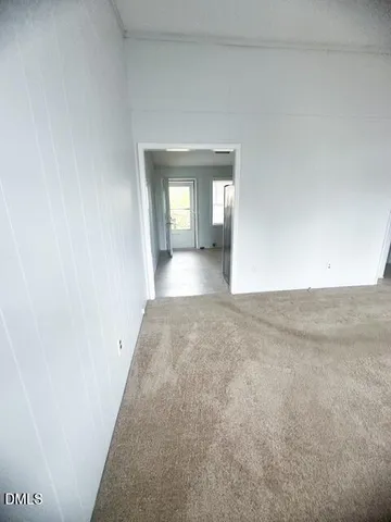 a view of a hallway with wooden floor and a window