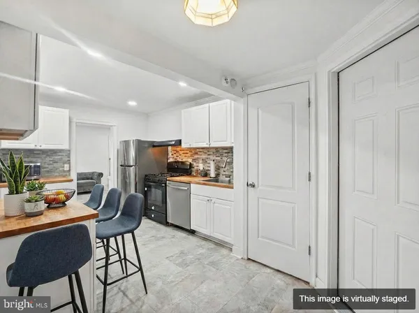 a kitchen with a refrigerator and white cabinets